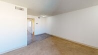 Located in Phoenix, AZ, this single-floor unit features 2 bedrooms, 1 bathroom, and a kitchen within a compact and efficiently designed layout. The living area transitions between wood-look vinyl plank flooring and neutral wall-to-wall carpeting found throughout the bedrooms, providing a warm, consistent feel. The primary bedroom is generously sized, offering ample space for furnishings, and features two closet doors along one wall—ideal for storage. A second bedroom is bright and naturally lit by a window that lets in abundant Arizona sunshine, with soft carpet underfoot and a textured ceiling overhead. The kitchen is equipped with warm wood-toned cabinetry extending to the ceiling for maximum storage, white appliances including a refrigerator, range, and dishwasher, and a double-basin sink. Wood-look plank flooring completes the kitchen's clean, functional aesthetic. The full bathroom includes a white tub and shower combination with chrome fixtures and tile flooring, keeping the space practical and easy to maintain. Throughout the unit, white walls and textured ceilings create a neutral canvas, while ceiling-mounted lighting provides consistent illumination. The straightforward floor plan ensures easy flow between all rooms, making this a well-organized and livable space in the heart of Phoenix.