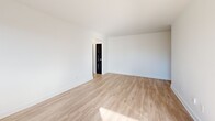 Located on the 8th floor at 250 Roehampton Ave in Toronto's Midtown neighbourhood, this one-bedroom, one-bathroom unit offers a well-organized layout across a single floor. Light hardwood-style flooring runs throughout the unit, giving the space a clean, cohesive feel.

The galley-style kitchen is outfitted with white cabinetry, dark countertops, stainless steel appliances including a dishwasher and oven range, and a window that brings in natural light. It connects seamlessly to the living areas, which benefit from large windows and a glass-panelled door that frames open city views of the Toronto skyline.

The living room is a bright, open space with abundant natural light streaming in through oversized windows overlooking surrounding midtown buildings. The bedroom is a comfortable size, featuring mirrored sliding closet doors that reflect light and enhance the sense of space, along with a window with baseboard heating below.

The bathroom is finished with classic white subway tile surrounding a full soaker tub with an overhead shower, complemented by chrome fixtures and a frosted window for natural ventilation. A hallway connects the main rooms, completing the functional flow of the unit. Bold black interior doors add a striking contrast to the otherwise crisp, white interior palette throughout.