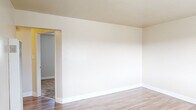Located at 20499 Santa Maria Ave in Castro Valley, CA, this single-floor, one-bedroom, one-bathroom home offers a practical and well-organized layout across a compact but efficiently utilized footprint. The living room greets you with warm wood-look laminate flooring, neutral cream-toned walls, clean white baseboards, and a large window that draws in natural light while offering views of the surrounding neighborhood. The kitchen is thoughtfully designed with white cabinetry, light countertops, a gas range, and a ceiling fan overhead, complemented by a window fitted with horizontal blinds. The open kitchen layout allows for easy movement and connectivity to the dining or living area. The bedroom features plush carpeting, a ceiling fan with light fixture, and a window with blinds that provides natural light and outdoor views, creating a comfortable and restful retreat. A dedicated closet adds practical storage. The bathroom is clean and bright, outfitted with a white vanity with under-cabinet storage, a large mirror, and a full tub and shower combination framed by white tile surround, with a frosted window for natural light. A hallway connects the rooms, completing this well-maintained and move-in-ready single-level home in the heart of Castro Valley.