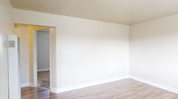 Located at 20499 Santa Maria Ave in Castro Valley, CA, this single-floor, one-bedroom, one-bathroom home offers a practical and well-organized layout across a compact but efficiently utilized footprint. The living room greets you with warm wood-look laminate flooring, neutral cream-toned walls, clean white baseboards, and a large window that draws in natural light while offering views of the surrounding neighborhood. The kitchen is thoughtfully designed with white cabinetry, light countertops, a gas range, and a ceiling fan overhead, complemented by a window fitted with horizontal blinds. The open kitchen layout allows for easy movement and connectivity to the dining or living area. The bedroom features plush carpeting, a ceiling fan with light fixture, and a window with blinds that provides natural light and outdoor views, creating a comfortable and restful retreat. A dedicated closet adds practical storage. The bathroom is clean and bright, outfitted with a white vanity with under-cabinet storage, a large mirror, and a full tub and shower combination framed by white tile surround, with a frosted window for natural light. A hallway connects the rooms, completing this well-maintained and move-in-ready single-level home in the heart of Castro Valley.