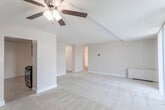 This single-floor residence offers a well-organized layout that balances open living spaces with functional private areas. The living room is generously sized, finished with neutral-toned carpeting and a ceiling fan with integrated lighting. A large sliding glass door lined with vertical blinds fills the space with natural light and provides outdoor views of surrounding greenery, creating a bright and airy atmosphere.

Adjacent to the living area, the kitchen is efficiently designed with rich dark-espresso cabinetry offering ample upper and lower storage. Light-toned countertops contrast the cabinetry, and the space is equipped with stainless steel appliances including a refrigerator, gas range, built-in microwave, and dishwasher. Tile flooring runs throughout the kitchen, complementing the overall neutral palette.

The unit includes two bedrooms, each carpeted in soft neutral tones. Both rooms feature windows that admit natural light, with one bedroom benefiting from a full-length sliding glass door. Baseboard heating units are present in each room.

Two full bathrooms serve the unit, each featuring a bathtub-shower combination, tile flooring in a mosaic pattern, and clean white fixtures, providing a straightforward and functional design throughout.