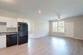 Located at 151 S Davis Rd in LaGrange, Georgia, this well-designed 2-bedroom, 2-bathroom single-story home offers a comfortable and functional layout with thoughtful finishes throughout. The exterior features modern board-and-batten siding and a small yard, adding curb appeal.

The open-concept main living area seamlessly connects the kitchen, dining, and living spaces. The kitchen is outfitted with white shaker-style cabinetry, dark countertops, and a full suite of black appliances including a refrigerator, range, microwave, and dishwasher. Light wood-style flooring runs throughout the main living areas, enhancing the bright, airy atmosphere created by multiple windows.

Both bedrooms are carpeted and feature ceiling fans, generous natural light from large windows with blinds, and individual closets. The primary bedroom includes a spacious walk-in closet with wire shelving for organized storage. Each bathroom is finished with wood-look flooring, a tub/shower combo, and a vanity with dark countertops.

Additional spaces include a utility room, a laundry area, and three closets total, providing ample storage. The neutral color palette, recessed lighting, and clean architectural lines give the home a fresh, move-in-ready appeal suited for comfortable everyday living.