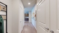 This thoughtfully designed 1-bedroom, 1-bathroom residence offers a functional and modern living experience across a single floor. Light wood-look flooring flows seamlessly throughout, lending a clean, cohesive aesthetic to every room.

A welcoming hallway with recessed lighting and a softly painted accent wall leads into the heart of the home. The open-concept kitchen and living area form the central gathering space. The kitchen is equipped with stainless steel appliances, rich dark-toned wood cabinetry extending to the ceiling, granite countertops, and a classic white subway tile backsplash — a combination that balances style and practicality. A breakfast bar provides additional prep and dining space.

The living room is bright and airy, benefiting from multiple windows that invite natural light and offer views of the surrounding neighborhood. A ceiling fan adds to the comfort of the space.

The bedroom is a calm, neutral retreat with its own ceiling fan and a well-sized window for natural light. It provides direct access to the full bathroom, which features a granite-topped vanity, dark wood cabinetry matching the kitchen, and a tiled soaking tub and shower combination. A dedicated walk-in closet with wire shelving systems offers generous storage capacity.

The overall ambiance is clean, modern, and inviting throughout.