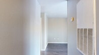This single-floor, 2-bedroom, 3-bathroom residence offers a thoughtfully designed layout that maximizes functionality and comfort. The open-concept dining and kitchen area features warm wood-toned cabinetry, light countertops, and black appliances including a refrigerator, range, and dishwasher, all set on durable wood-look flooring. The spacious living area extends naturally to a private covered balcony through sliding glass doors, offering pleasant outdoor views of the surrounding neighborhood.

The primary bedroom is generously sized and showcases vaulted ceilings with a ceiling fan, soft carpet flooring, and a closet with built-in shelving and hanging rods. The second bedroom also features carpeted floors and a window with blinds that allows natural light to filter in. Both bedrooms are served by well-appointed bathrooms featuring wood-toned vanities with stone-look countertops and tub-shower combinations.

Throughout the common areas, wood-look plank flooring provides a cohesive and low-maintenance aesthetic, complemented by neutral gray walls and clean white trim. The residence also includes two closets for ample storage and a dedicated laundry area, rounding out a complete and practical living space.