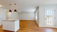 Located at 1344 New Britain Ave in West Hartford, CT, this well-appointed single-floor residence offers a clean, modern aesthetic carried consistently throughout every room. Warm hardwood-style flooring flows seamlessly from the open-concept living and dining area into the kitchen and bedrooms, creating a cohesive and inviting atmosphere.

The kitchen is a standout feature, outfitted with crisp white shaker cabinetry, granite countertops, a classic subway tile backsplash, and a full suite of stainless steel appliances including a refrigerator, dishwasher, microwave, and range. A peninsula with pendant lighting provides additional counter space and serves as a natural divider between the kitchen and the bright, open living area.

The bedrooms are generously sized with neutral tones and ample natural light from well-placed windows. At least one bedroom includes a spacious walk-in closet with wire shelving for organized storage.

Two full bathrooms serve the unit, both finished with granite-topped white vanities, large mirrors, and tiled surrounds. One features a glass-enclosed walk-in shower, while the other offers a full soaking tub. Both maintain the clean, consistent design language found throughout the space, making this a thoughtfully designed and move-in ready home.