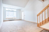 Located at 1118 N Pleasant View Rd in Madison, WI, this two-story home offers a thoughtfully arranged layout spread across two floors. The main level provides a comfortable living area with neutral carpet flooring, warm wood trim accents, and baseboard heating. Natural light fills the space through generously sized windows. The upper level is a standout, featuring vaulted ceilings with a skylight that floods the area with natural light, along with a wood-railed open staircase that connects both floors seamlessly. Ceiling fans are present in the bedrooms, enhancing comfort throughout. The two bedrooms are well-proportioned, with the primary bedroom offering notable space and access to a walk-in closet equipped with multiple wood shelving units and hanging rods. The two full bathrooms are finished with wood-toned doors, white cabinetry, and wood-look vinyl plank flooring. One bathroom includes both a separate shower stall with sliding glass doors and a soaking tub, while the second features a wide vanity with a large mirror. A dedicated laundry area houses a full-size washer and dryer with overhead wood shelving. With four closets total, storage is abundant throughout this well-appointed Madison home.