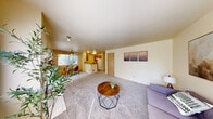 Located in Federal Way, WA, this 2-bedroom, 2-bathroom residence offers a well-organized single-floor layout designed for comfortable everyday living. The living room serves as the heart of the home, featuring plush carpeting, warm neutral tones, and a classic fireplace as a central focal point. Large windows invite natural light throughout, and a sliding door provides access to an outdoor area. The galley-style kitchen is efficiently designed with warm wood cabinetry, laminate countertops, hardwood-style flooring, and white appliances including a refrigerator, range, and dishwasher. A peninsula counter connects the kitchen to the dining and living areas, creating an open, functional flow. Both bedrooms are carpeted and offer generous closet storage, with the primary bedroom featuring direct access to a bathroom. The secondary bedroom benefits from a window with outdoor views and ample natural light. Two full bathrooms each include a shower/tub combination with clean, simple finishes and hardwood-style flooring. Throughout the residence, the warm cream-toned walls and neutral palette create a calm, cohesive ambiance suited for a wide range of lifestyles.