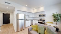Located on E Fountain Blvd in Colorado Springs, CO, this efficiently designed 2-bedroom, 1-bathroom unit offers a clean, modern aesthetic across a single floor. The open-concept kitchen and living area form the heart of the space, featuring a full suite of stainless steel appliances—including a refrigerator, electric range, over-the-range microwave, and dishwasher—paired with crisp white cabinetry, neutral countertops, and recessed lighting. Light wood-look flooring runs throughout the main living area, enhancing the bright and airy atmosphere.

Two hallways connect the living spaces to the private rooms, maintaining a logical and functional layout. The primary bedroom offers a sliding-door closet and neutral carpeting, while the second bedroom features a window that brings in natural light and views of the surrounding area. Both rooms are finished with clean white walls that lend a versatile, move-in-ready feel.

The bathroom is well-appointed with a white vanity cabinet, integrated sink, neutral countertop, and a well-lit mirror with overhead lighting. Throughout the unit, consistent use of white tones, recessed lighting, and understated finishes creates a cohesive, modern living environment well-suited for everyday comfort in an urban Colorado Springs setting.