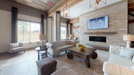 Located at 2214 Vintage Tollgate Dr in Thompson's Station, Tennessee, this single-story clubhouse blends rustic charm with modern sophistication through a carefully curated design aesthetic. The space is defined by striking reclaimed wood ceilings with exposed beams that span the main gathering areas, creating warmth and architectural character throughout.

The open-concept layout flows seamlessly between distinct functional zones. A well-appointed bar area features granite countertops with a herringbone tile backsplash, an undermount sink, beverage dispenser, and wall-mounted televisions — ideal for social gatherings. Decorative barn door-style accents add to the rustic theme in this area.

The lounge area showcases a stone-clad fireplace with a mounted flat-screen television, tufted seating, and ornate wood furnishings beneath reclaimed wood beam ceilings and statement pendant lighting. A billiards table anchors a central game area, reinforcing the space's entertainment focus.

A dedicated dining area features large dining tables surrounded by upholstered seating beneath raised paneled walls. Expansive sliding glass doors flood this room with natural light and provide direct views of the open Tennessee landscape beyond, connecting the interior to the surrounding greenery. Wood-look tile flooring runs throughout, tying all areas together cohesively.