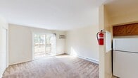 Located at 335 Florence Ave in Westville, NJ, this one-bedroom, one-bathroom unit offers a practical and efficiently designed single-floor layout. The combined living and dining area is bright and inviting, featuring wall-to-wall carpeting, a wall-mounted A/C unit, and a sliding glass door that opens to an outdoor deck, allowing natural light to fill the space. Baseboard heating runs along the perimeter for year-round comfort. The kitchen is equipped with warm wood cabinetry, a tile backsplash, a ceiling fan, and white appliances including a refrigerator, electric range, and dishwasher, all set over durable tile flooring. The bedroom is a comfortable, carpeted retreat featuring a wall-mounted A/C unit, a window with natural light and outdoor views, and a set of double sliding closet doors for convenient storage. Throughout the unit, five closets provide ample storage. The bathroom includes a full tub and shower combination enclosed by sliding glass doors, tile surround, and a small window for ventilation. Neutral tones and clean white walls throughout the unit create a move-in-ready environment well-suited for comfortable everyday living.