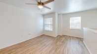 Located at 6815 W University Ave in Gainesville, FL, this two-bedroom, two-bathroom two-story unit offers a well-organized and functional layout spread across two levels. The lower level serves as the entryway, with the staircase leading up to the main living area. Light wood-style flooring runs throughout, creating a clean and cohesive aesthetic.

The upper floor hosts the majority of the living space, including an open-concept area combining the living room, dining room, and kitchen. The kitchen is appointed with gray cabinetry, white countertops, a double-basin sink, and a full suite of stainless steel appliances including a gas range, microwave, dishwasher, and refrigerator. A breakfast bar provides additional counter space and a natural transition into the dining and living areas, which are brightened by multiple windows.

Both bedrooms feature light wood-style flooring, ceiling fans with lighting, and ample natural light from windows. The primary bedroom is generously sized and connects to its own bathroom. A second full bathroom includes a tub-shower combination. The unit also includes multiple closets for storage and a dedicated in-unit laundry area, adding everyday convenience to this practical and well-appointed Gainesville home.