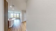 This 1250 square foot apartment in Peridot Palms offers a thoughtfully designed living space with three bedrooms and two bathrooms. The open-concept layout seamlessly integrates the kitchen, living, and dining areas, creating a spacious feel enhanced by light-colored walls and warm wood-tone flooring throughout.

The kitchen is a standout feature, boasting modern wood-grain cabinetry, stainless steel appliances, and a mosaic tile backsplash. A large island with a white countertop provides additional workspace and casual seating. The living area is illuminated by recessed lighting and a stylish ceiling fan, with ample space for comfortable furnishings.

Each bedroom offers generous proportions, with the primary bedroom measuring 190 square feet. All bedrooms feature closets with wire shelving systems for optimal organization. The bathrooms are elegantly appointed with stone-look tile flooring, modern vanities, and updated fixtures. One bathroom showcases a tiled shower enclosure with a decorative accent strip.

The apartment includes a dedicated laundry room with full-size washer and dryer, as well as additional storage cabinets. Throughout the home, attention to detail is evident in the crisp baseboards, modern door handles, and cohesive design elements that create a contemporary and inviting atmosphere.
