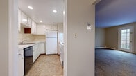 Located at 1260 N Forest Rd in Buffalo, New York, this single-floor unit offers a practical and straightforward layout designed for comfortable everyday living. The kitchen is equipped with ample white cabinetry, generous counter space with light-colored countertops, a dishwasher, a white refrigerator, and a white range, all set atop durable tile flooring in a neutral stone-inspired pattern. Recessed lighting keeps the kitchen bright and functional.

The living area features wall-to-wall carpeting in a medium-toned grey-brown, neutral warm-beige painted walls, and baseboard heating running along the perimeter for efficient climate control. A private entry door opens directly into this space, providing easy access.

The bedrooms are carpeted and share a consistent design language with neutral tones and clean white trim. Each room is fitted with wall-mounted air conditioning units and benefits from natural light through double-hung windows dressed with horizontal blinds, offering views of the surrounding landscape. At least one bedroom includes a full-width sliding-door closet, providing ample storage. Baseboard heating is present throughout, ensuring year-round comfort. The overall ambiance is clean, understated, and move-in ready.