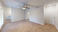 This 2-bedroom, 2-bathroom single-story residence at 1000 N Donahue Dr in Auburn, Alabama, offers a well-designed layout with modern finishes throughout. Light-toned wood-look flooring runs continuously across the space, creating a cohesive and clean aesthetic in every room.

The kitchen is a standout feature, equipped with white shaker-style cabinetry, granite countertops, a subway tile backsplash, and stainless steel appliances including a refrigerator, dishwasher, and range. A peninsula with matching granite provides additional prep space and casual seating potential, while pendant lighting adds a polished touch.

The open living area adjoins the kitchen and features a ceiling fan with light, neutral gray walls, and a glass door that invites natural light and outdoor access. Both bedrooms are comfortably sized, with the spacious primary bedroom offering ample room to furnish. Each bedroom is fitted with a ceiling fan, wood-look flooring, and access to closet space.

The two bathrooms mirror each other in finish, each featuring granite-topped vanities, wood-look flooring, and full tub-shower combinations with clean white surrounds. A connecting hallway ties all rooms together efficiently. The overall ambiance is bright, neutral, and move-in ready.