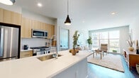 Located at 394 West Ave in Norwalk, CT, this modern 2-bedroom, 2-bathroom residence offers a thoughtfully designed single-floor layout with contemporary finishes throughout. The open-concept living room is bright and welcoming, featuring large floor-to-ceiling windows that frame views of the surrounding neighborhood and flood the space with natural light. Dark hardwood-style flooring anchors the living and kitchen areas, creating a cohesive, modern aesthetic. The kitchen is a standout feature, centered around a generous island with a white quartz countertop, undermount sink, and stylish pendant lighting. Light wood cabinetry pairs seamlessly with stainless steel appliances, including a French door refrigerator, gas range, microwave, and dishwasher. The spacious primary bedroom offers soft carpeting, windows with neighborhood views, and access to a well-appointed en-suite bathroom featuring a double-sink vanity with light wood cabinetry, tile flooring, and a glass-enclosed shower. A walk-in closet with wire shelving provides ample storage. The second bedroom is generously sized with carpeted floors and bright windows. The second bathroom includes a single vanity with matching light wood cabinetry, tile flooring, and a shower-tub combination. A dedicated closet rounds out this well-organized and modern Norwalk residence.