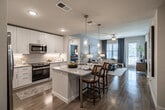 Located in Punta Gorda, Florida, this thoughtfully designed 2-bedroom, 2-bathroom residence offers a comfortable and functional single-floor layout. The open-concept living and dining area features light wood-look flooring, soft neutral tones, and large windows that invite natural light throughout. The living room provides a relaxed ambiance with ample space for entertaining.

The kitchen is a standout feature, boasting white shaker cabinetry, granite countertops, stainless steel appliances, and a peninsula with bar seating illuminated by pendant lighting — ideal for casual dining. A separate dining area accommodates a full table and connects seamlessly to the kitchen.

The primary bedroom offers a generous footprint with plush carpeting and a walk-in closet equipped with wire shelving. Its en-suite bathroom features a dual-sink vanity with granite countertops, a glass-enclosed shower, and tile flooring. The second bedroom is well-sized with its own closet, and the second bathroom includes a full tub-shower combo with tile surround. Two hallways connect the spaces efficiently, and two closets provide abundant storage throughout the residence.