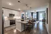 Located in Punta Gorda, Florida, this thoughtfully designed 2-bedroom, 2-bathroom residence offers a comfortable and functional single-floor layout. The open-concept living and dining area features light wood-look flooring, soft neutral tones, and large windows that invite natural light throughout. The living room provides a relaxed ambiance with ample space for entertaining.

The kitchen is a standout feature, boasting white shaker cabinetry, granite countertops, stainless steel appliances, and a peninsula with bar seating illuminated by pendant lighting — ideal for casual dining. A separate dining area accommodates a full table and connects seamlessly to the kitchen.

The primary bedroom offers a generous footprint with plush carpeting and a walk-in closet equipped with wire shelving. Its en-suite bathroom features a dual-sink vanity with granite countertops, a glass-enclosed shower, and tile flooring. The second bedroom is well-sized with its own closet, and the second bathroom includes a full tub-shower combo with tile surround. Two hallways connect the spaces efficiently, and two closets provide abundant storage throughout the residence.
