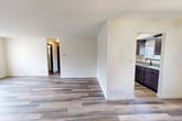 Located in Murrysville, PA, this two-story home offers a thoughtfully designed layout across two levels. The main living area is expansive and open, featuring light-toned wood-look flooring that flows seamlessly throughout, creating a bright and cohesive atmosphere. The living room and dining room connect naturally, with the dining area highlighted by a striking geometric pendant light fixture and access to a staircase with dark wood railings. The kitchen is well-appointed with dark cabinetry, granite-style countertops, stainless steel appliances including a refrigerator, range, and microwave, plus a sink with an outdoor-facing window. A dedicated laundry room with utilities and electrical panel access is conveniently located off the kitchen. Two carpeted staircases with a handrail connect the levels. Both bedrooms feature wood-look flooring, neutral walls, windows with outdoor views of the surrounding greenery, and closets with dark bifold doors. The two bathrooms are clean and functional, each offering a tub-shower combination, vanity with under-sink storage, and modern fixtures. Three closets throughout provide ample storage. The overall aesthetic is clean, modern, and move-in ready.