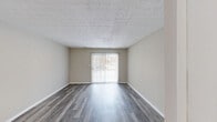 Located at 220 E Hoover Dr in Fort Wayne, Indiana, this single-floor, 2-bedroom, 2-bathroom home offers a practical and well-organized layout. The open living and dining area is a central highlight, featuring durable wood-look flooring in a cool gray tone, neutral beige walls, and a textured ceiling. A sliding glass door with vertical blinds fills the space with natural light and provides outdoor access. The kitchen is efficiently designed with white cabinetry, light stone-look countertops, black appliances including an electric range, a stainless steel sink, and wood-look tile flooring. The primary bedroom is generously sized with soft wall-to-wall carpet, a textured ceiling, and an abundance of built-in closet space with multiple sliding-door closets. The second bedroom also features carpet flooring, a textured ceiling, and a window allowing natural light. Both bathrooms include tiled tub-shower combinations with clean, classic white finishes. The home also includes a dedicated laundry area, a hallway connecting all rooms, and a total of three closets providing excellent storage throughout. The overall aesthetic is clean, neutral, and move-in ready.