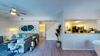 This two-story residence offers a thoughtfully designed layout across two levels. The main living area features light wood-style flooring, a ceiling fan, and a sliding glass door that opens to a private balcony — an ideal space for relaxing outdoors. A built-in shelving niche adds functional character to the living room, while a pass-through window connects seamlessly to the kitchen. The kitchen is outfitted with stainless steel appliances, including a range, microwave, and dishwasher, complemented by granite countertops, crisp white cabinetry, and a double-basin sink beneath a window. In-unit washer and dryer connections are conveniently accessible from the main level. The primary bedroom includes a walk-in closet and a dedicated en-suite bath, while additional bedrooms provide comfortable, carpeted accommodations with ample natural light. A second bathroom features a tub-shower combination, and a half bath with a dark granite vanity top and round mirror serves as a practical guest facility. Throughout the home, neutral tones and clean finishes create a bright, modern ambiance suitable for a range of living arrangements.
