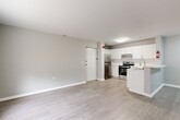 Located in the heart of Wilmington, Delaware, this thoughtfully designed 2-bedroom, 1-bathroom residence offers a clean, modern aesthetic across a single floor. Light gray walls, crisp white trim, and durable light-toned luxury vinyl plank flooring run throughout, creating a cohesive and contemporary atmosphere.

The open-concept living and kitchen area anchors the space, with the kitchen featuring white shaker-style cabinetry, light quartz countertops, a subway tile backsplash, stainless steel appliances including a range, dishwasher, and refrigerator, and a peninsula with an overhang ideal for casual dining. The adjacent living area is bright and welcoming, offering easy flow between spaces.

Both bedrooms are well-proportioned, with the primary bedroom providing ample room for a full furniture arrangement. Each bedroom benefits from windows with natural light and access to closet space. The second bedroom is equally functional and versatile.

The full bathroom is outfitted with a soaking tub and shower combination, brushed nickel grab bars, a white vanity, and coordinating flooring. A dedicated utility room rounds out the floor plan, adding practical storage and functionality. The unit also includes a dedicated entry door, providing a sense of privacy and ease of access.
