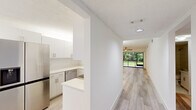 Located at 9623 Cypress Park Way in Boynton Beach, Florida, this well-appointed single-story home offers 2 bedrooms and 3 bathrooms across a thoughtfully designed floor plan. Light wood-style flooring flows consistently throughout the home, complemented by a neutral color palette and textured ceilings that create a clean, modern aesthetic.

The open kitchen features white shaker-style cabinetry, light quartz countertops, stainless steel appliances including a large French door refrigerator and dishwasher, and a convenient pass-through that connects to the main living areas. Adjacent dining and living spaces are bright and airy, anchored by a ceiling fan and expansive sliding glass doors that open to a screened porch with serene, tree-lined outdoor views.

Both bedrooms are well-sized with ceiling fans and natural light. The spacious primary bedroom offers generous proportions with easy access to one of the three bathrooms, which features large-format tile work, a walk-in shower with pebble stone flooring, and clean, minimalist finishes. A dedicated laundry room provides added convenience with built-in shelving. Two hallways connect the rooms efficiently, and a closet offers additional storage. The screened enclosure off the living room provides a peaceful retreat surrounded by Florida greenery.