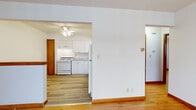 This 2-bedroom, 1-bathroom residence offers a practical and efficiently arranged single-floor layout. Warm hardwood flooring flows consistently throughout, complemented by clean white walls and wood-trimmed baseboards that lend a cohesive look across all rooms.

The living area provides a welcoming entry point, featuring a solid wood front door and a built-in shelf unit. A connecting hallway leads to the remaining spaces. The kitchen is well-appointed with white shaker-style cabinetry, granite-look countertops, a double stainless steel sink, and white appliances including a gas range, dishwasher, and refrigerator. A ceiling fan adds airflow to the space.

The primary bedroom offers a comfortable footprint with hardwood floors and a floor vent for climate control. The second bedroom benefits from two windows that allow natural light and views of surrounding greenery. Both rooms feature clean white walls and warm wood flooring throughout.

The bathroom is neatly finished with tile-surround tub and shower, a white vanity with mirror, wall-mounted lighting, and wood-look flooring. The hallway connects all rooms efficiently, keeping the overall layout logical and easy to navigate. This space is well-suited for those seeking a straightforward, functional home with consistent finishes throughout.