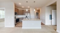 This thoughtfully designed 2-bedroom, 2-bathroom residence in Charlotte, NC offers a comfortable and modern living experience across a single floor. The open-concept kitchen serves as the heart of the home, showcasing a large center island with a double granite sink, pendant lighting, stainless steel appliances including a range, microwave, and refrigerator, warm-toned cabinetry, and a classic white subway tile backsplash. The kitchen flows seamlessly into the living area, which benefits from natural light streaming through large windows and a ceiling fan overhead, with views of the surrounding neighborhood.

Both bedrooms are carpeted and well-proportioned, each featuring windows that invite natural light and ceiling fans for comfort. The primary bedroom is generously sized and is supported by a dedicated walk-in closet outfitted with wire shelving systems for organized storage.

The two bathrooms are finished with consistent, upscale detailing — granite countertops, dark wood cabinetry, and wood-look luxury flooring. The primary bathroom includes a glass-enclosed walk-in shower, while the second bathroom features a full soaking tub and shower combo. Neutral tones throughout the space create a clean, cohesive aesthetic that is both modern and inviting.