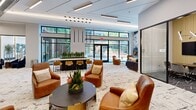 Located at 630 Washington Ave in Belleville, NJ, this single-floor amenity lounge is a thoughtfully designed communal space that blends modern aesthetics with functional versatility. The open-plan layout offers a generous and airy atmosphere, anchored by soaring ceilings, sleek linear LED lighting, and floor-to-ceiling windows that flood the interior with natural light and provide views of the surrounding outdoor areas.

The main lounge area features a sophisticated mix of cognac leather lounge chairs, navy accent sofas, and contemporary round coffee tables, all set atop a textured, abstract-patterned carpet that anchors the space in refined style. A long communal high-top bar table with gold-toned stools serves as a central gathering point, while a bold marble-effect feature wall and integrated flat-screen television add visual drama.

A glass-enclosed conference room offers a more private setting, equipped with a large boardroom table, amber upholstered seating, a wall-mounted display screen, and striking geometric pendant lighting. An additional breakout lounge zone, defined by a dramatic dark wood slatted partition, provides intimate seating for smaller groups.

Throughout, the design palette of white, charcoal, and warm gold tones creates a cohesive, upscale ambiance suited for both social gatherings and productive work sessions.