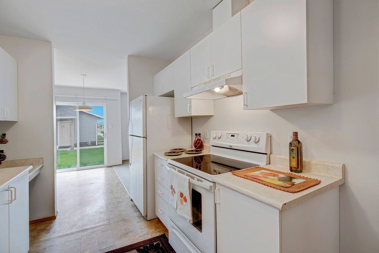 An open kitchen with white cabinets - Carrington Place