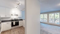 Located at 6400 Sycamore Ln N in Maple Grove, MN, this one-bedroom, one-bathroom residence offers a practical and well-organized single-floor layout. The kitchen features white cabinetry, dark countertops, a stainless steel range, and wood-look flooring, creating a clean and functional cooking space. A partial wall separates the kitchen from the living area, which is carpeted and bathed in natural light through large sliding glass doors that open to views of mature trees. The living room also includes a fireplace, adding a cozy focal point to the space. The bedroom is comfortably sized, with soft carpet, a window overlooking the greenery outside, and a baseboard heating system. The full bathroom is straightforward and functional, featuring a tub-shower combination. Throughout the unit, textured ceilings and neutral tones create a consistent, understated aesthetic. Baseboard heating is present in multiple rooms, and the living area includes a wall-mounted air conditioning unit. The hallway connects the living spaces efficiently, contributing to the overall ease of the floor plan. This residence offers a quiet setting with natural surroundings in the established Maple Grove community.