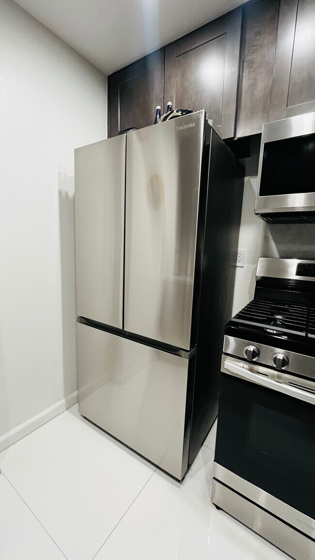 New kitchen With stainless steel refrigerator, dishwasher, microwave, and stove. Garbage disposal - 6600 Warner Ave