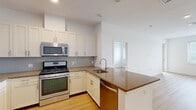 Located at 2050 Central Rd in Fort Lee, NJ, this two-bedroom, two-bathroom residence offers a thoughtfully designed single-floor layout with a clean, modern aesthetic throughout. Light wood-tone flooring flows consistently across the living spaces and bedrooms, creating a warm and cohesive feel. The combined kitchen and living room serves as the heart of the home, featuring a well-equipped kitchen with white shaker-style cabinetry, granite countertops, a subway tile backsplash, stainless steel appliances including a gas range, microwave, and refrigerator, and a undermount sink — all designed for both functionality and style. The spacious primary bedroom offers generous room to furnish comfortably and includes a dedicated walk-in closet fitted with wire shelving and hanging rods. The second bedroom is bright and well-proportioned, benefiting from natural light through a window with views of the surrounding area, and also features its own walk-in closet. Both bathrooms are finished with light tile flooring, a soaking tub with curved shower rod, a vanity with storage, and clean white walls. The overall ambiance of the residence is bright, neutral, and move-in ready, reflecting a modern and practical design sensibility.
