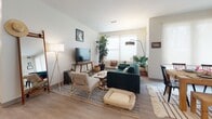 This single-floor residence at 2841–2871 Church Ave in Cleveland, Ohio offers a thoughtfully designed open-concept layout that seamlessly connects the living, dining, and kitchen areas. Light wood-tone flooring runs throughout the main living spaces, complementing the neutral, light-toned walls that create a bright and airy atmosphere. Multiple windows fitted with roller shades allow ample natural light to fill the space.

The kitchen is a standout feature, showcasing white shaker cabinetry, dark granite countertops, a subway tile backsplash, stainless steel appliances including a range, microwave, and French door refrigerator, and a large central island with bar seating illuminated by pendant lighting. The open living and dining area provides generous space for both relaxing and entertaining.

The bedrooms are carpeted for comfort. The primary bedroom includes access to a spacious walk-in closet with wire shelving systems. Two bathrooms serve the unit: one features a double-sink vanity with dark countertops and a tiled walk-in shower, while the second offers a single vanity and a shower-tub combination, both finished with white cabinetry and wood-look flooring.