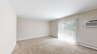 Located at 151 S Bishop Rd in Secane, PA, this two-bedroom, one-bathroom unit offers a comfortable and functional single-floor layout. The living area is bright and spacious, featuring wall-to-wall carpet, a ceiling fan, and a sliding glass door that opens to a private balcony overlooking lush, mature greenery. Baseboard heating runs throughout the unit, providing consistent warmth across all rooms. The kitchen is well-appointed with white shaker-style cabinetry, grey laminate countertops, a stainless steel sink, and a classic subway tile backsplash, complemented by hardwood-style flooring that adds a warm contrast to the neutral palette. The generously sized primary bedroom offers plush carpeting, a large window with outdoor views, and ample closet space with bifold doors. The second bedroom is similarly carpeted and well-lit, also featuring a closet. A connecting hallway with additional closet storage links the bedrooms. The bathroom includes a full tub-and-shower combination finished with warm-toned rectangular tile surround and brushed nickel fixtures. Neutral wall tones and clean white trim are consistent throughout, creating a cohesive and move-in-ready aesthetic.