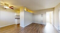 Located at 6717 Wilkinson Ave in North Hollywood, Los Angeles, this efficiently designed one-bedroom, one-bathroom unit offers a well-organized single-floor layout across a compact yet functional footprint. Rich, dark hardwood-style flooring runs throughout the main living areas, lending a warm and cohesive aesthetic to the space.

The living room is bright and open, featuring a ceiling fan, a wall-mounted heater, and French doors that lead directly to a private patio — a seamless indoor-outdoor connection ideal for the Southern California climate. A dedicated dining area sits adjacent to the living space, providing a natural flow for everyday living.

The galley-style kitchen is thoughtfully appointed with white cabinetry, granite-look countertops, a double sink, and a white gas range. A ceiling light fixture and efficient layout make the kitchen practical and easy to navigate.

The bedroom is carpeted for comfort and features a mirrored sliding closet, a ceiling fan, a wall-mounted AC unit, and a row of windows that invite natural light and offer leafy outdoor views. A dedicated closet provides additional storage.

The bathroom includes a vanity with granite-look countertops and white cabinetry, a medicine cabinet with mirror, and a combined tub and shower enclosure with sliding glass doors. The unit also benefits from access to a patio surrounded by mature trees.