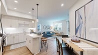 Located at 1445 Town Center Dr in Chula Vista, CA, this thoughtfully designed single-floor residence offers three bedrooms and two bathrooms within a bright, contemporary layout. The open-concept kitchen, dining, and living area forms the heart of the home, showcasing white shaker cabinetry extending to the ceiling, subway tile backsplash, stainless steel appliances, and a central island with bar seating illuminated by modern pendant lights. Warm-toned hardwood-style flooring flows throughout the main living spaces, connecting the kitchen seamlessly to the dining area and a comfortable living room filled with natural light from multiple windows and a glass exterior door. The primary bedroom features plush carpet, a ceiling fan, a large window, and sliding glass doors opening to a private outdoor patio. A spacious walk-in closet with multi-tier hanging rods adds generous storage. Secondary bedrooms also feature carpet and ample natural light. Two clean, modern bathrooms include white quartz vanities, wood-toned cabinetry, large mirrors, and tub-shower combinations. A dedicated hallway and closet round out the efficient, well-organized floor plan, making this a comfortable and stylish home throughout.