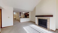 Located at 6801 S Parkedge Cir in Franklin, Wisconsin, this single-floor home offers a well-designed layout with a comfortable, functional flow throughout. The open-concept living area is a standout feature, showcasing vaulted ceilings that lend an airy, expansive feel to the space. Natural light streams in through large windows, illuminating the plush carpeted floors. A tile-surround fireplace with a wood mantle serves as a focal point in the living room, adding warmth and character. The kitchen is open to the main living area and features rich, dark espresso-toned cabinetry, granite-style laminate countertops, a stainless steel refrigerator, and wood-look tile flooring. A peninsula with a sink provides additional workspace and casual seating. The bedrooms are generously sized with soft carpeting and ample closet space, including built-in shelving. One bedroom features a large window with views of the surrounding landscape. The bathrooms are well-appointed with dark vanity cabinetry, stone-look countertops, wood-look vinyl flooring, and full tub-shower combinations. A convenient half bath with a well-lit vanity mirror adds practicality. The overall ambiance is neutral, clean, and move-in ready.