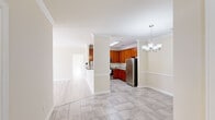 Located at 201 Tiliwa Ct in Clemson, South Carolina, this single-floor home offers a well-designed layout with clean finishes and a bright, welcoming atmosphere throughout. Crown molding is a consistent architectural detail that lends a polished look to every room.

The kitchen is a standout feature, showcasing rich warm-toned cabinetry that extends to the ceiling, granite countertops, and a full suite of stainless steel appliances including a refrigerator, range, microwave, and dishwasher. A skylight overhead floods the space with natural light, and pendant lighting adds a refined touch. The kitchen opens to a dining area illuminated by an elegant chandelier, creating a seamless flow between cooking and entertaining spaces.

Light-toned tile flooring runs through the kitchen and main living areas, while wood-look flooring carries through the bedrooms, contributing to the home's cohesive and airy aesthetic. A versatile room features French doors that open to the outdoors and a ceiling fan, making it ideal as a sunroom, office, or additional living space.

The bedrooms are generously proportioned with ample natural light from windows with blinds. The bathroom is neatly appointed with a tub-shower combination, granite-topped vanity, and tile flooring. A dedicated laundry area with washer and dryer hookups adds everyday convenience to this well-appointed home.
