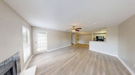 Located at 6000 Hollister St in Houston, TX, this single-story, 2-bedroom, 2-bathroom home offers a practical and comfortable layout designed for everyday living. The open living room is a standout feature, boasting light wood-style flooring, a ceiling fan, multiple windows that invite abundant natural light, and a classic fireplace framed in dark tile — creating a warm, inviting atmosphere. A front entry door with a windowed panel further brightens the space. The kitchen is efficiently designed in a galley style, featuring granite-style countertops, gray cabinetry, black appliances including a range, microwave, and refrigerator, plus a stainless steel sink — all illuminated by a skylight panel overhead. A peninsula counter connects the kitchen to the living area, ideal for casual dining or entertaining. Both bedrooms are carpeted and equipped with ceiling fans, offering a comfortable retreat. The spacious primary bedroom includes direct access to a private closet and an en-suite bathroom. The second bedroom also benefits from natural light through large windows. Both bathrooms are appointed with granite-style countertops, tub-shower combinations with white tile surrounds, and a clean, neutral palette. A hallway connects the rooms efficiently, completing this well-organized floor plan.