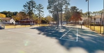 This tennis facility, located at 1067 Pitts Rd in Sandy Springs, GA, offers a comprehensive recreational experience. The property features multiple tennis courts with hard surfaces, ideal for both casual play and competitive matches. A standout element is the raised gazebo structure, accessible via stairs, providing an excellent vantage point for spectators or coaches.

The courts are surrounded by chain-link fencing, ensuring ball containment and player safety. Ample lighting fixtures are installed, allowing for evening play. The facility is nestled within a residential area, with apartment-style buildings visible nearby, suggesting a community-oriented setting.

Landscaping around the courts includes mature trees, providing natural shade and a picturesque backdrop. The property appears well-maintained, with clean court surfaces and neatly trimmed vegetation. Additional amenities may include seating areas and possibly other recreational facilities not visible in the provided images.

The overall ambiance is one of a suburban oasis, offering residents and visitors a dedicated space for tennis enthusiasts. The combination of well-kept facilities and natural surroundings creates an inviting atmosphere for both serious players and those looking for leisurely outdoor activity.