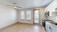 Located at 1148 North Main Street in Jacksonville, Florida, this one-bedroom unit offers a thoughtfully designed layout that maximizes every square foot of its compact footprint. The open living area features light wood-tone flooring, crisp white walls, and a ceiling fan, creating a bright and airy atmosphere. Multiple windows dressed with blinds, along with a glass-panel exterior door, flood the space with natural light and provide access to an outdoor area with exterior views.

The kitchen is well-appointed with white upper shaker-style cabinets, gray lower cabinets, a classic white subway tile backsplash, and gray countertops. Stainless steel appliances — including a range, over-the-range microwave, dishwasher, and refrigerator — provide full functionality in an efficient footprint.

A hallway fitted with a stylish sliding barn door with matte black hardware connects the main living space to the bedroom, and a dedicated closet with built-in shelving and hanging rods offers organized storage. The bedroom is a comfortable, well-proportioned retreat with neutral carpet flooring and a ceiling fan, conveying a calm and restful ambiance. A connecting door leads conveniently to the kitchen area, enhancing the overall flow of the unit.