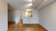 Located at 400 Wall St in Seattle's Belltown neighborhood, Unit 519 is a thoughtfully designed one-bedroom residence offering a functional and comfortable single-floor layout. The open-concept living, dining, and kitchen area serves as the heart of the home, featuring warm hardwood-style flooring, neutral wall tones, and a sliding glass door that opens to a private balcony with natural views of surrounding trees. The kitchen is equipped with white cabinetry, granite countertops, stainless steel appliances including a refrigerator and microwave, and a peninsula with bar seating that seamlessly connects to the living and dining space. Track and flush-mount lighting illuminate the main areas effectively. The bedroom is carpeted and generously sized, benefiting from a large window that brings in natural light. Two closets provide ample storage, including a walk-in closet with wire shelving. The bathroom features tile flooring, a granite-topped vanity, and a soaking tub with shower. A dedicated den adds flexible space for a home office or guest area. In-unit laundry and a dedicated entrance complete this practical and well-rounded residence in the heart of Seattle.