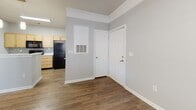 Located at 101 Breakers Dr in Myrtle Beach, South Carolina, this single-floor unit offers a thoughtfully designed layout with a clean, modern aesthetic throughout. Wood-look plank flooring flows through the main living areas, complemented by soft gray walls and crisp white trim and crown molding that lend a polished finish to every room.

The open living and dining area is highlighted by a ceiling fan, generous natural light from blinds-fitted windows, and a charming arched pass-through that connects to the kitchen, adding an architectural touch to the space. The galley-style kitchen is well-equipped with light maple cabinetry, white countertops, a tile mosaic backsplash, and black appliances including a refrigerator, electric range with microwave, and dishwasher.

The bedrooms offer comfortable accommodations, with one featuring plush carpet and a bright window, and another showcasing a trio of windows with a ceiling fan, filling the room with natural light and wood-look flooring. The bathroom includes a single-vanity with wood cabinetry, a large mirror, and a tub-shower combination, all finished with wood-look flooring for a cohesive look. A dedicated laundry area with a full-size washer and dryer and overhead wire shelving adds everyday convenience to this well-rounded Myrtle Beach residence.