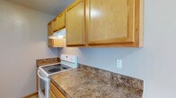 Located at 89 Riverview Dr in Saint Albans, West Virginia, this single-floor residence offers a practical and comfortable living environment. The kitchen is a standout feature of the home, showcasing warm honey-toned wood cabinetry that extends to the upper walls, providing generous storage space. The countertops display a laminate surface with a rich, earthy granite-like pattern, offering ample workspace for meal preparation. A white electric range is seamlessly integrated into the kitchen layout, positioned beneath a built-in range hood for effective ventilation. The cabinetry's natural wood finish lends a warm, welcoming atmosphere to the kitchen, complemented by soft, neutral-toned walls that keep the space feeling bright and open. The overall design reflects a straightforward, functional aesthetic suited for everyday living. Situated in Saint Albans, a community along the Kanawha River in West Virginia, this property combines practical interior features with the charm of its riverside location, making it a well-rounded option for those seeking comfortable, single-level living in the area.