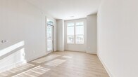 Located at 346 W 26th St in Charlotte, NC, this single-floor, 2-bedroom, 1-bathroom home offers a clean, modern aesthetic throughout. The living room features light hardwood-style flooring, crisp white walls, and large windows with transom details that flood the space with natural light and provide views of the surrounding neighborhood. A glass-paneled exterior door adds additional brightness to the area.

The kitchen is a functional standout, equipped with white shaker-style cabinetry, a tile backsplash, granite countertops, and a central island with bar seating. Black appliances, including a refrigerator, range, and microwave, provide a bold contrast to the white cabinetry and light flooring.

Both bedrooms are carpeted and well-lit by large windows. The primary bedroom includes a walk-in closet with wire shelving, offering practical storage. The second bedroom is comfortably sized with neutral tones throughout.

The bathroom features wood-style flooring, a white vanity with granite countertops, a large mirror, and a combined tub and shower. Clean lines and neutral finishes carry the home's consistent modern style into this space, completing a well-designed and cohesive living environment.