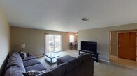 Located at 1901 S Goyer Rd in Kokomo, Indiana, this single-floor residence offers a practical and comfortable layout designed for everyday living. The open living room is generously sized, featuring neutral-toned carpet, warm wall colors, and a sliding glass door that fills the space with natural light and provides access to the outdoors. The room flows naturally toward a dedicated dining nook, where a ceiling fan with light fixture and a window enhance the bright, airy atmosphere adjacent to the kitchen. The kitchen is equipped with white cabinetry, laminate countertops, a range, dishwasher, and refrigerator, all set atop easy-to-maintain tile flooring. The bedrooms are carpeted and well-proportioned, each featuring windows that bring in natural light. The primary bedroom includes a spacious reach-in closet with built-in shelving and rod, while the secondary bedroom offers ample room and dresser storage. The full bathroom is outfitted with a tub-shower combination, toilet, and vanity. Throughout the home, neutral wall tones and consistent finishes create a cohesive and functional living environment suited for a range of occupants.