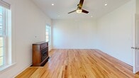 Located at 1178 Meagan Ct in Elgin, IL, this well-appointed three-story home offers a thoughtfully designed layout with quality finishes throughout. The main level showcases a gourmet kitchen equipped with rich cherry wood cabinetry, granite countertops, stainless steel appliances including a gas range and built-in microwave, and glass-front upper cabinets. Natural light flows in through multiple windows, offering views of the surrounding landscape. Warm hardwood flooring extends through the main and upper levels, lending continuity and a classic aesthetic. The upper floor hosts generously sized bedrooms, each with ceiling fans and ample natural light. A walk-in closet with a custom built-in organization system—featuring shelving, hanging rods, and drawers—provides excellent storage. The upper level also includes a dedicated laundry room with a full-size front-loading washer and dryer. Bathrooms are elegantly finished with large-format marble-look porcelain tile, glass-enclosed tub-shower combinations, and clean white vanities. The finished lower level offers a standout home theater room with tiered leather recliner seating and recessed lighting, creating an immersive entertainment experience. This home combines practical functionality with refined details across all three levels.