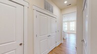 Located at 16408 Holly Crest Lane in Huntersville, NC, this well-appointed 2-bedroom, 3-bathroom residence offers a thoughtfully designed single-level layout. The open-concept kitchen and living area serves as the heart of the home, featuring warm hardwood flooring, abundant natural light, and a bay window area with direct access to a private balcony. The kitchen is equipped with stainless steel appliances, white shaker cabinetry reaching to the ceiling, a classic subway tile backsplash with a decorative diamond tile accent, and light-toned countertops. Both bedrooms are carpeted and feature tray ceilings with ample natural light from large windows. The generously sized primary bedroom includes a walk-in closet with built-in wire shelving and an en suite bathroom complete with a glass-enclosed tile shower, a vanity with under-mount sink, and tile flooring. A spacious walk-in tile shower is also found in a second full bathroom. Three closets throughout the home provide excellent storage. Additional spaces include a laundry room and utility room, rounding out a practical and comfortable floor plan well-suited for everyday living.