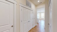 Located at 16408 Holly Crest Lane in Huntersville, NC, this well-appointed 2-bedroom, 3-bathroom residence offers a thoughtfully designed single-level layout. The open-concept kitchen and living area serves as the heart of the home, featuring warm hardwood flooring, abundant natural light, and a bay window area with direct access to a private balcony. The kitchen is equipped with stainless steel appliances, white shaker cabinetry reaching to the ceiling, a classic subway tile backsplash with a decorative diamond tile accent, and light-toned countertops. Both bedrooms are carpeted and feature tray ceilings with ample natural light from large windows. The generously sized primary bedroom includes a walk-in closet with built-in wire shelving and an en suite bathroom complete with a glass-enclosed tile shower, a vanity with under-mount sink, and tile flooring. A spacious walk-in tile shower is also found in a second full bathroom. Three closets throughout the home provide excellent storage. Additional spaces include a laundry room and utility room, rounding out a practical and comfortable floor plan well-suited for everyday living.